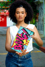 Load image into Gallery viewer, Woman holding a colorful clutch with graffiti-style design on a street.