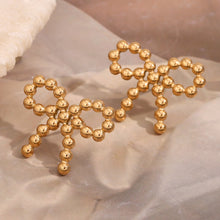 Load image into Gallery viewer, 18k Gold plated bow-shaped earrings on a beige fabric background