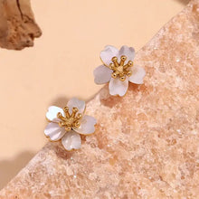 Load image into Gallery viewer, Delicate flower-shaped earrings with white petals and gold center on a white background. They emit an elegant, sophisticated tone.