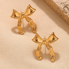Load image into Gallery viewer, 18k Gold plated bow-shaped earrings on a beige fabric background