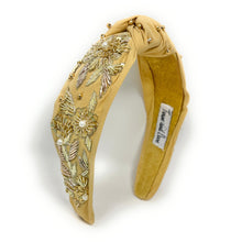 Load image into Gallery viewer, Golden padded headband adorned with intricate floral embroidery and pearl accents, exuding elegance and sophistication against a plain backdrop.