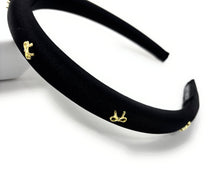 Load image into Gallery viewer, Elegant black satin headband adorned with small gold bow embellishments, displayed against a plain white background, conveying a stylish and chic tone.