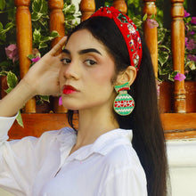 Load image into Gallery viewer, Woman wearing a white shirt with a decorative headband and earrings, standing against a colorful background.