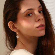 Load image into Gallery viewer, Close-up of a woman wearing gold earrings with a neutral background