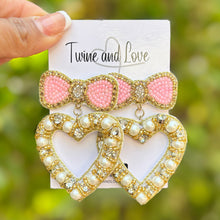 Load image into Gallery viewer, heart with bow jeweled Earrings, pink bow heart valentines Earrings, Valentines Day Earrings, Valentines Beaded Earrings, Valentines Heart earrings, sweetheart earrings, valentine’s day beaded earrings, dainty valentines beaded earrings, valentines beaded earrings, unique earrings, Valentine’s day earrings, tween girls accessories, Valentine’s day accessories, Best selling items, Valentines accessories, pearly heart earrings, custom earrings, gifts for her, handmade gifts, unique valentines heart earrings