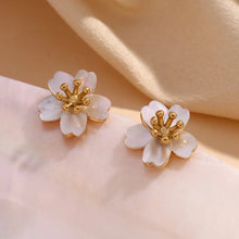 Load image into Gallery viewer, Delicate flower-shaped earrings with white petals and gold center on a white background. They emit an elegant, sophisticated tone.