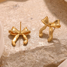 Load image into Gallery viewer, 18k Gold plated bow-shaped earrings on a textured beige surface