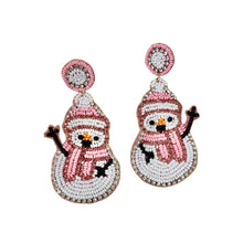 Load image into Gallery viewer, Beaded snowman earrings featuring pink hats and scarves, with black arms and vibrant orange noses. The design conveys a playful, festive tone.