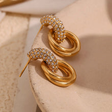 Load image into Gallery viewer, Gold earrings with zircon on a beige stone surface