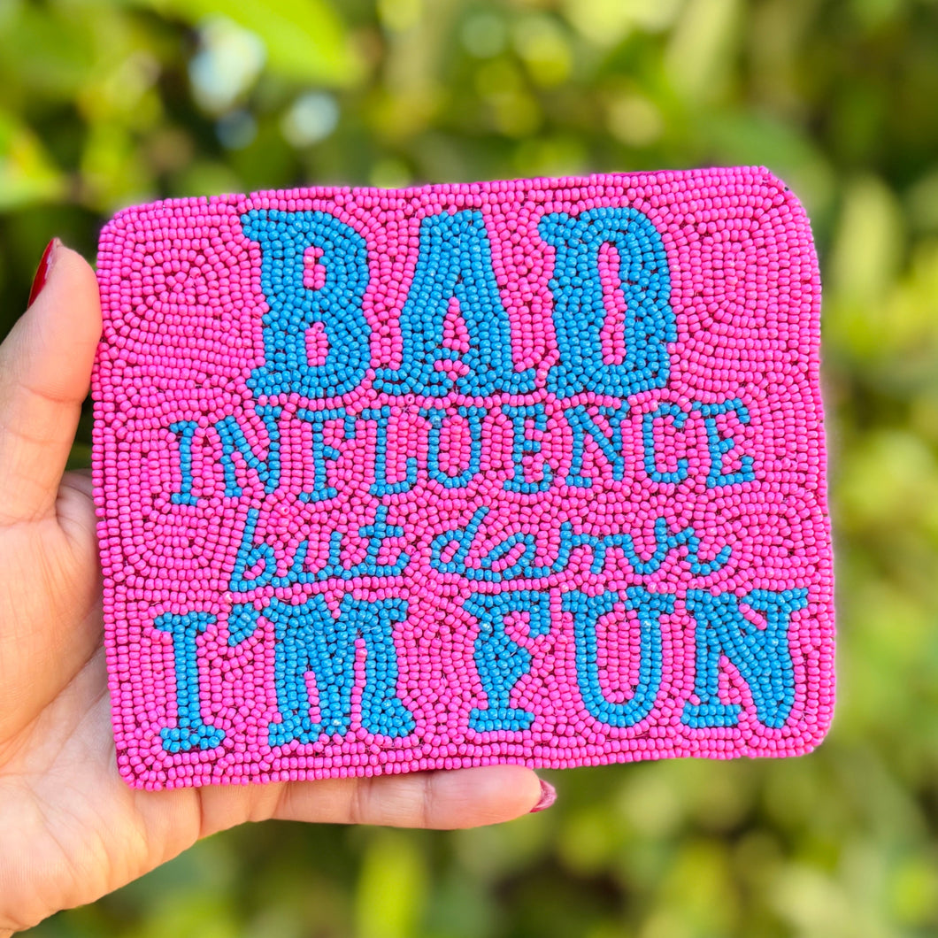 A pink clutch bag with blue beaded text reading 