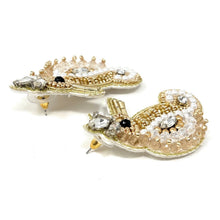 Load image into Gallery viewer, Close-up portrait of a woman wearing a woven beige headband and pearl-accented seahorse earrings for a coastal-inspired look.