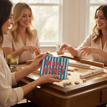 Load image into Gallery viewer, Three women smiling and playing a mahjong game around a wooden table, with one woman in the foreground holding a blue and white striped pouch labeled 'MAHJ MONEY'.