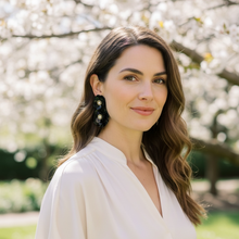 Load image into Gallery viewer, Woman in a white blouse standing in front of a cherry blossom tree