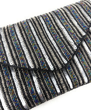 Load image into Gallery viewer, Silver and black sequined clutch with vertical stripes. It features a triangular flap and a silver chain strap, exuding a glamorous, elegant vibe.