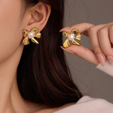 Load image into Gallery viewer, Gold bow-shaped earrings with pearls worn by a person against a neutral background