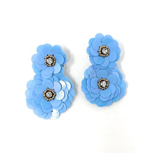 Load image into Gallery viewer, Pair of blue floral earrings with layered petals and sparkling rhinestone centers. The design is intricate and elegant, evoking a cheerful tone.