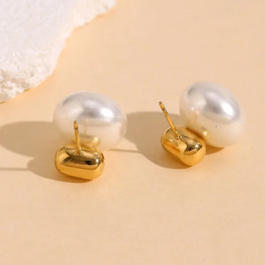 Pearl earrings with 18k gold plated bases on a beige background