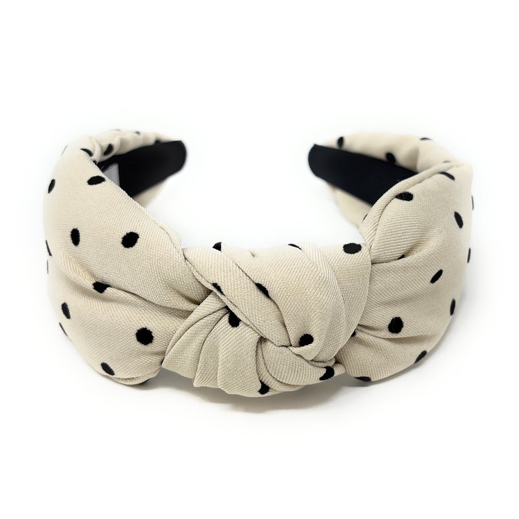 Beige headband with black polka dots on a white background
