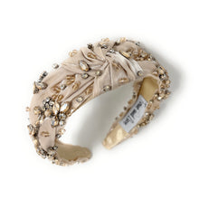 Load image into Gallery viewer, Elegant beige headband adorned with sparkling crystals and gemstones. The luxurious fabric is delicately ruched, creating a sophisticated and glamorous look.