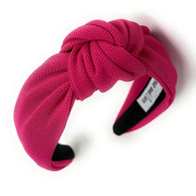 Load image into Gallery viewer, Stylish woman wearing a textured fuchsia headband with a center knot, creating a vibrant and modern look.