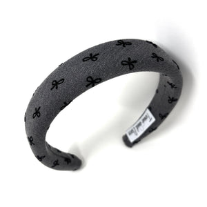 Gray headband with black bow patterns on a white background