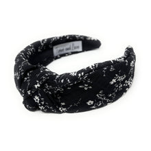 Load image into Gallery viewer, Black floral knotted headband with white ditsy print and padded twist detail on a neutral background.