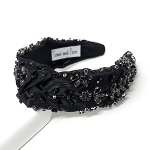 Elegant green headband adorned with sparkling crystals and gemstones. The luxurious fabric is delicately ruched, creating a sophisticated and glamorous look.