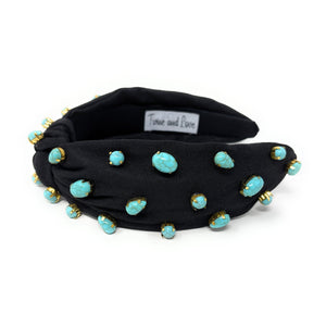 Elegant black headband adorned with turquoise beads, featuring a twist knot detail. The design is stylish and sophisticated.