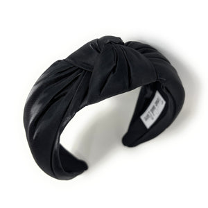 Black headband with a knot on a white background