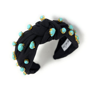 Elegant black headband adorned with turquoise and gold beads, featuring a twist knot detail. The design is stylish and sophisticated.