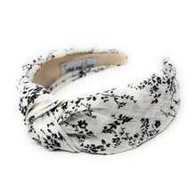 Load image into Gallery viewer, Black and white floral knotted headband with a soft twisted design on a neutral background.