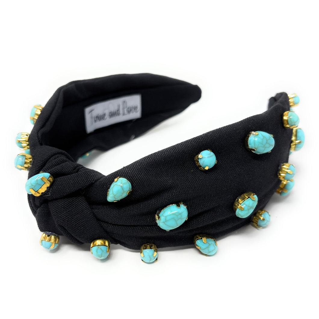 Elegant black headband adorned with turquoise beads, featuring a twist knot detail. The design is stylish and sophisticated.