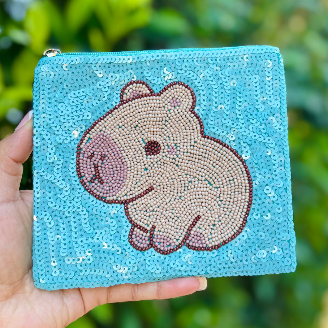 Blue sequin pouch featuring a cute capybara design in beige and brown beads. The playful, whimsical tone is accented by a silver zipper.