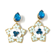 Load image into Gallery viewer, Elegant earrings featuring blue teardrop gems, gold star-shaped bases adorned with white and light blue flowers accented by small blue stones.