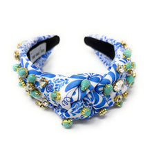 Load image into Gallery viewer, A blue and white floral-patterned headband adorned with turquoise stones and sparkling gems. It conveys a vibrant, elegant, and artistic flair.