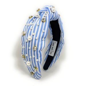 A stylish headband with blue and white stripes, adorned with pearls and sparkling gems. It has a knotted design, offering a chic and elegant look.