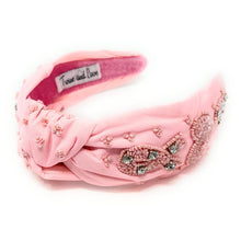Load image into Gallery viewer, Breast cancer awareness-inspired pink ribbon earrings highlighted in a stylish outfit with a blush crystal headband and minimal accessories.
