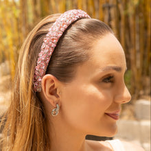 Load image into Gallery viewer, Woman wearing a blush pink crystal headband adorned with sparkling rhinestones and a chic knotted design.