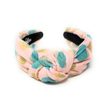 Load image into Gallery viewer, Blush pink knotted headband featuring a pastel seashell print in turquoise, sage green, and golden yellow on textured fabric. Lightweight padded hair accessory perfect for beach vacations, coastal style, and everyday wear by Twine and Love