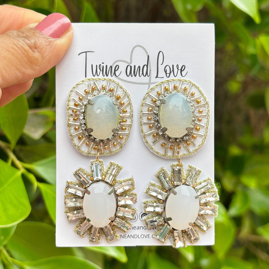 Elegant drop earrings with oval gray stones, surrounded by sparkling crystals. Each earring features two sections, exuding a luxurious and sophisticated vibe.
