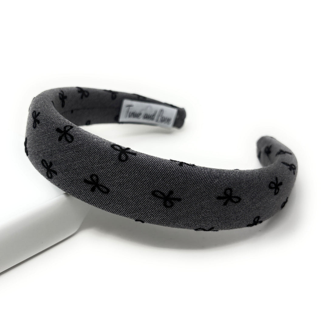 Gray headband with black bow pattern on a white background