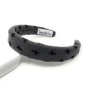 Gray headband with black bow pattern on a white background