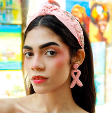 Load image into Gallery viewer, Handcrafted pink awareness ribbon earrings styled with a soft pink embellished headband and classic white ribbed top.