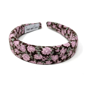 Floral-patterned headband featuring pink and green flowers on a brown background. 
