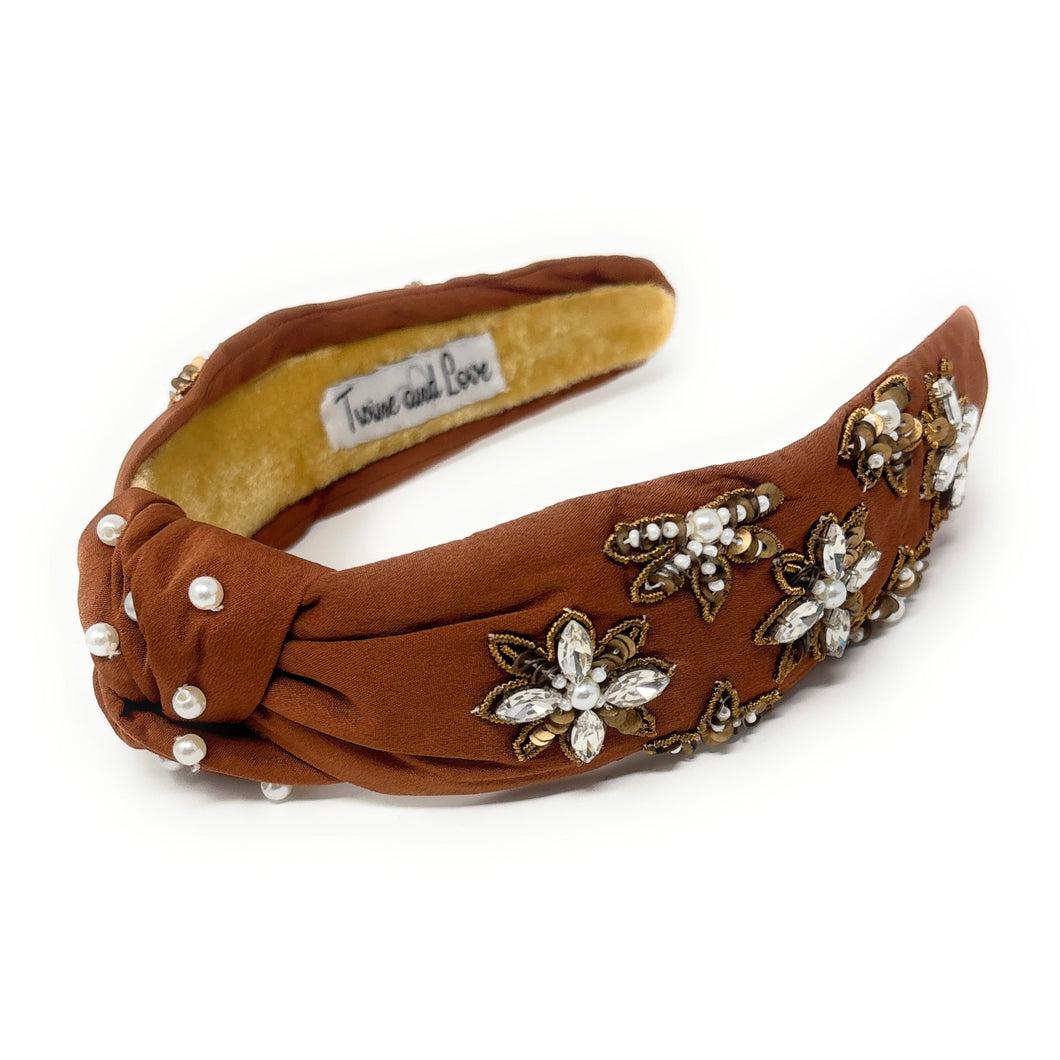 Brown headband adorned with pearl and crystal floral embroidery, exuding elegance. The interior is lined with soft beige fabric for comfort.