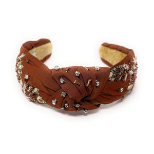 Brown headband with decorative elements on a white background