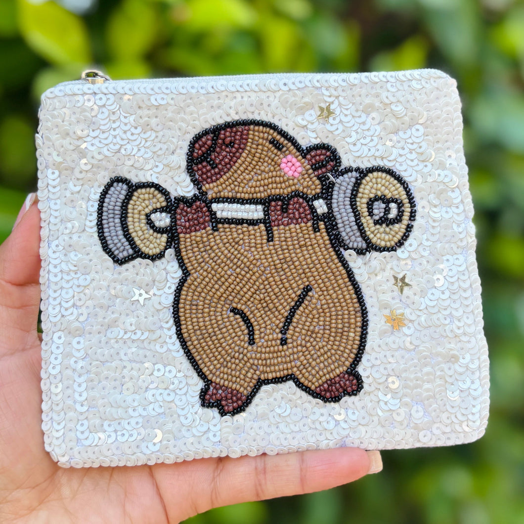 White sequined pouch with a cute capybara lifting weights design.