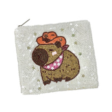 Load image into Gallery viewer, Sequined pouch featuring a cute capybara wearing an orange cowboy hat and pink bandana. Background covered in shiny white sequins, playful tone.