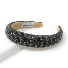 Load image into Gallery viewer, A dark beaded headband with intricate patterns on a white surface. The headband has a textured design and an elegant, luxurious appearance.