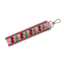 Load image into Gallery viewer, Hand beaded cherry wristlet keychain featuring red strawberries and green leaves on a pink beaded strap with green checker accents. Includes a gold-tone lobster clasp and comfortable wrist loop, perfect for carrying keys, key fobs, or ID badges.